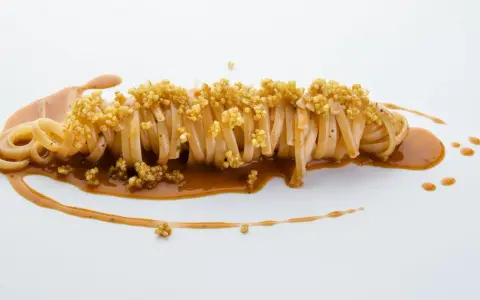 Pasta con carciofi Cannavacciuolo, un piatto elegante con pasta lunga, salsa cremosa e croccanti germogli di quinoa.