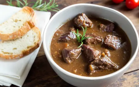 Cinghiale in umido fatto in casa da Benedetta, servito in una ciotola con pane tostato e rosmarino.