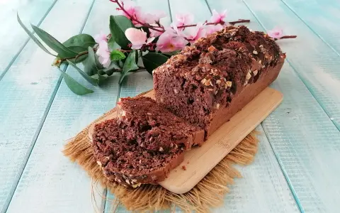 Plumcake al cioccolato senza uova, ricco e goloso, con noci tritate sulla crosta croccante. Perfetto per una colazione o merenda sana.