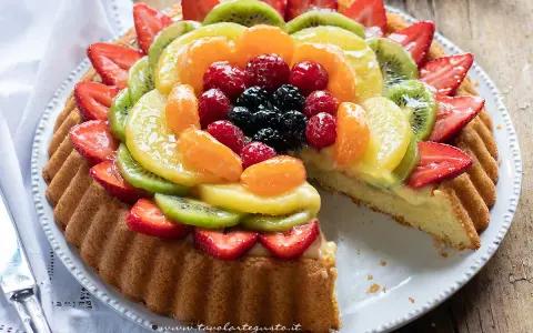 Una deliziosa crostata morbida alla frutta, con fragole, kiwi, mandarini e frutti di bosco, su una base soffice e crema pasticcera.