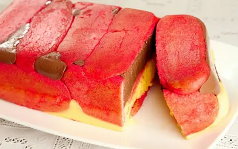 Zuppa inglese ricetta originale emiliana: strati di pan di Spagna rosa, crema al cioccolato e crema pasticcera, decorata con gocce di cioccolato.
