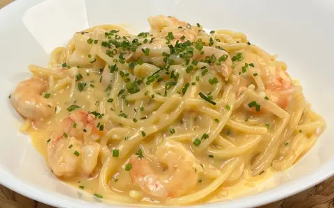 Spaghetti cremosi con gamberi e erba cipollina, una deliziosa carbonara di mare.