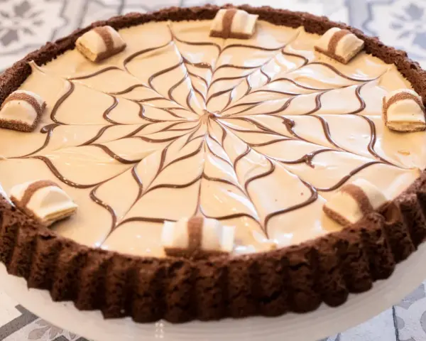 Torta Kinder Bueno con decorazione a ragnatela in cioccolato e pezzi di wafer.