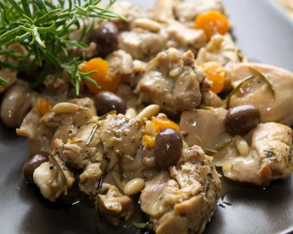 Coniglio alla ligure con olive, pinoli e rosmarino, un piatto saporito e profumato.