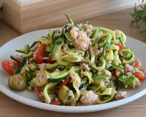 Deliziosa insalata di zucchine a spirale con tonno, pomodorini e olive verdi. Un piatto fresco e leggero.