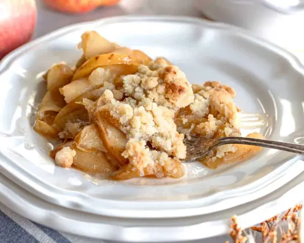 Un delizioso crumble di mele appena sfornato, con mele caramellate e una croccante copertura dorata.