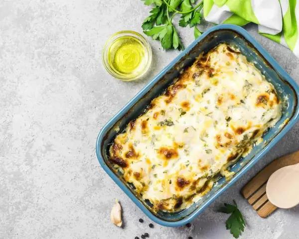 Zucchine al forno con mozzarella filante, dorate e profumate, pronte per essere gustate.