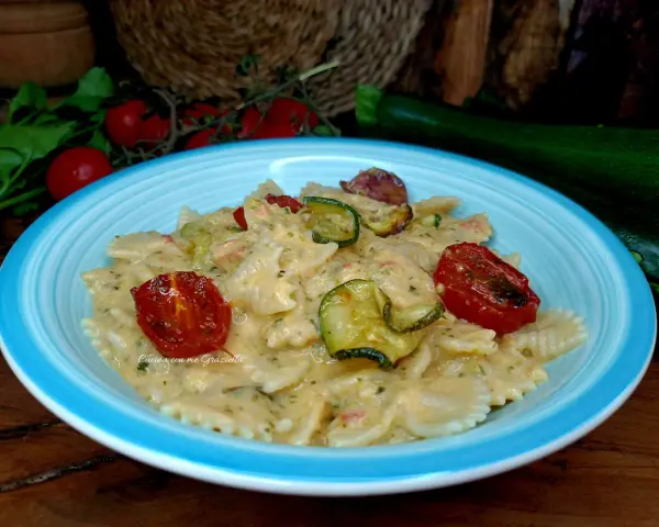 Farfalle cremose con zucchine e pomodorini confit, un piatto che celebra la pasta zucchine e philadelphia.