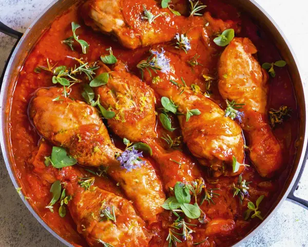 Succulento pollo alla cacciatora in padella, con erbe aromatiche fresche e scorza di limone.