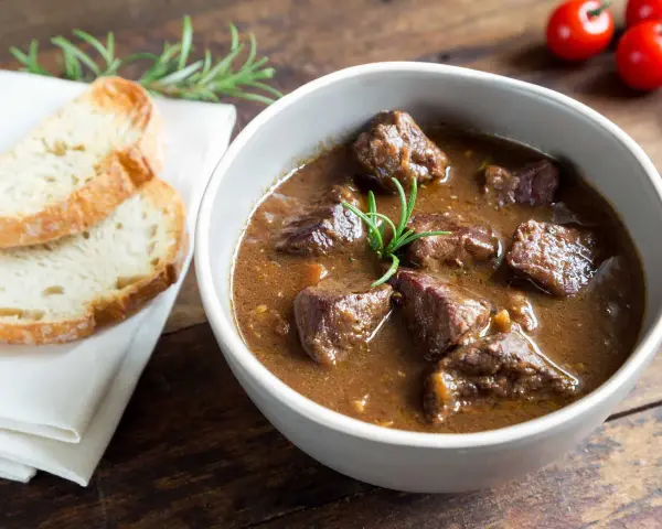 Cinghiale in umido fatto in casa da Benedetta, servito in una ciotola con pane tostato e rosmarino.