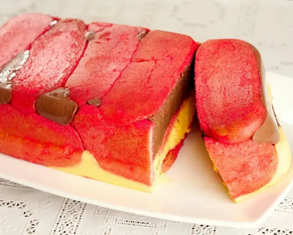 Zuppa inglese ricetta originale emiliana: strati di pan di Spagna rosa, crema al cioccolato e crema pasticcera, decorata con gocce di cioccolato.