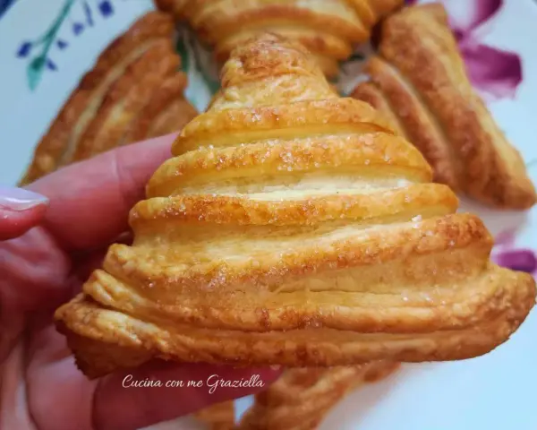 Sfogliatine dorate con zucchero, perfette per scoprire cosa mettere dentro la pasta sfoglia per un dolce sfizioso.