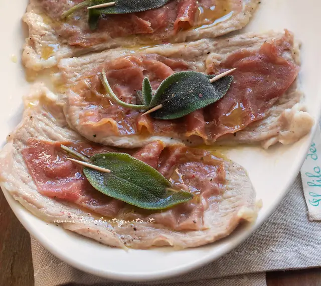 Saltimbocca alla romana: fettine di vitello con prosciutto crudo e salvia, condite con olio e pepe.