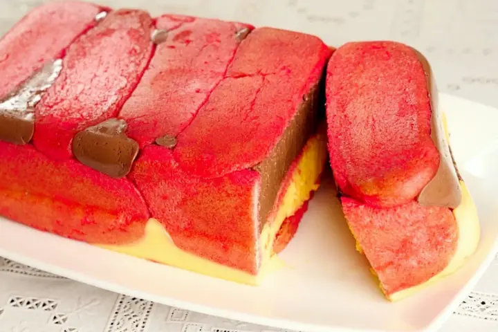 Zuppa inglese ricetta originale emiliana: strati di pan di Spagna rosa, crema al cioccolato e crema pasticcera, decorata con gocce di cioccolato.