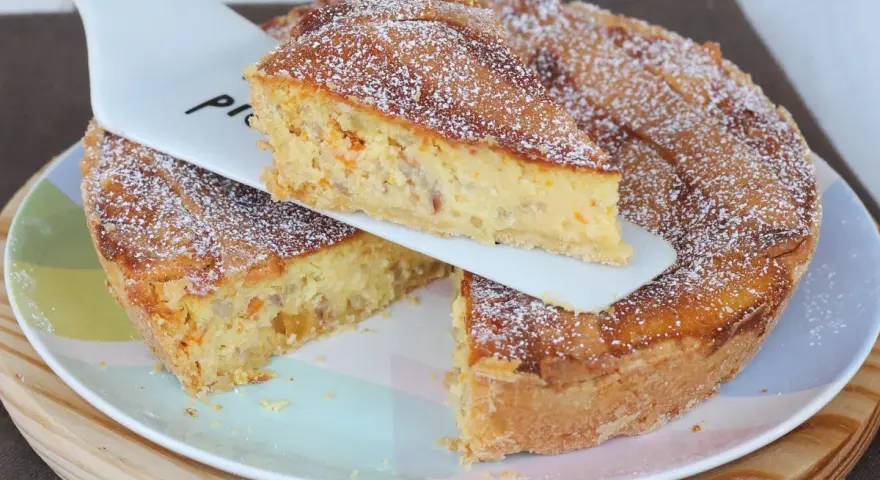 Una fetta di pastiera napoletana con pasta frolla, ricca di grano, ricotta e canditi, cosparsa di zucchero a velo.