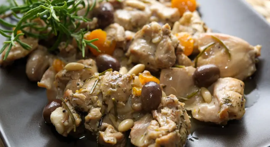 Coniglio alla ligure con olive, pinoli e rosmarino, un piatto saporito e profumato.