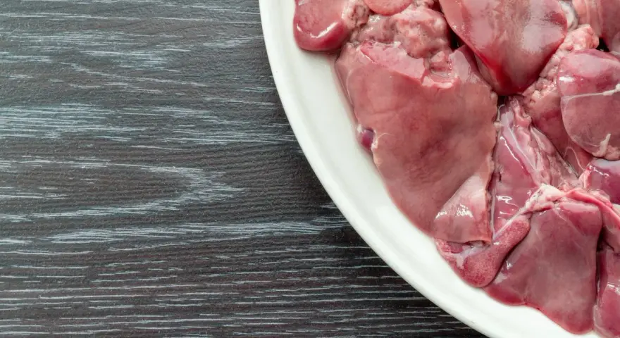 Un piatto bianco pieno di **durelli di pollo** crudi, pronti per essere cucinati.