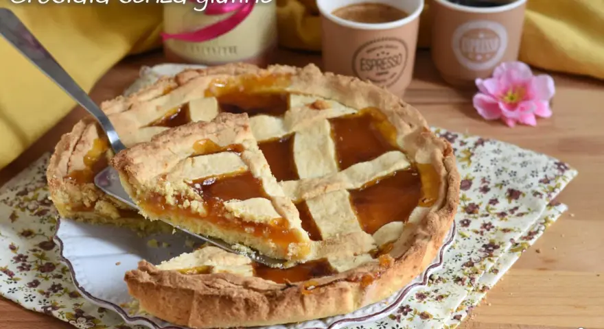 Una deliziosa crostata senza glutine con marmellata d'arancia, pronta per essere gustata con un caffè.