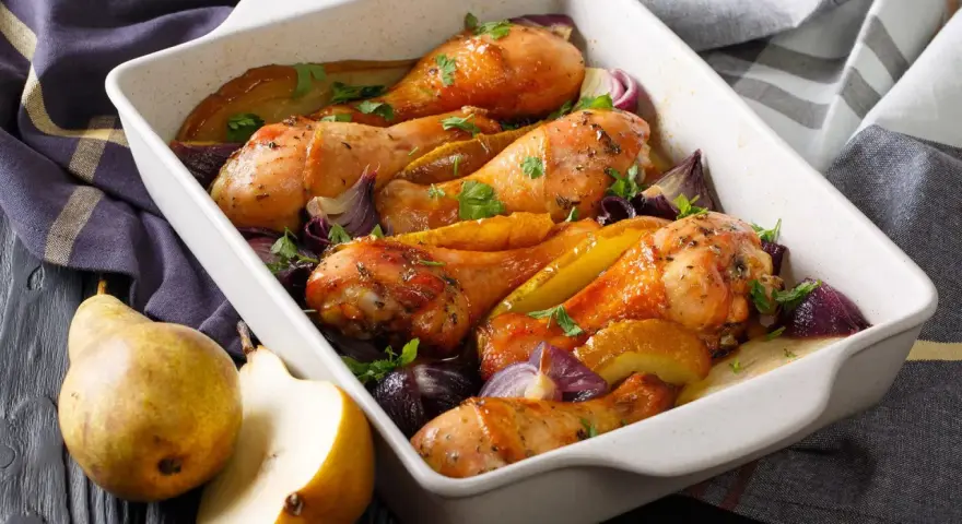 Cosce di pollo al forno dorate con pere, cipolle rosse e prezzemolo, un piatto succulento e profumato.