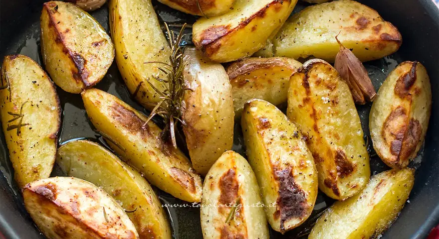 Patate al forno dorate e croccanti, condite con rosmarino e aglio, pronte per essere gustate.