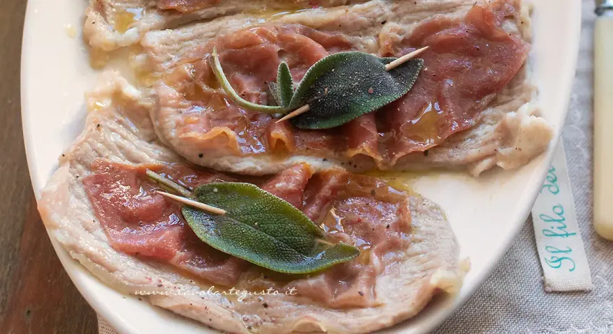 Saltimbocca alla romana: fettine di vitello con prosciutto crudo e salvia, condite con olio e pepe.