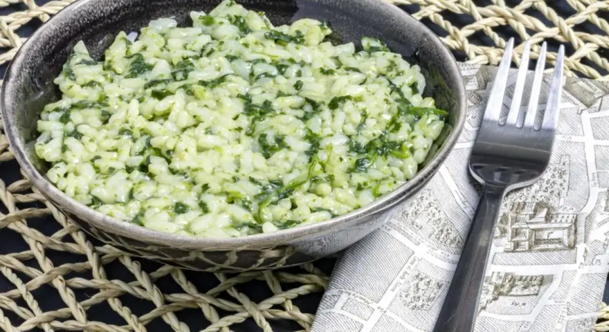 Cremoso risotto con spinaci, un piatto semplice e gustoso, pronto per essere gustato.