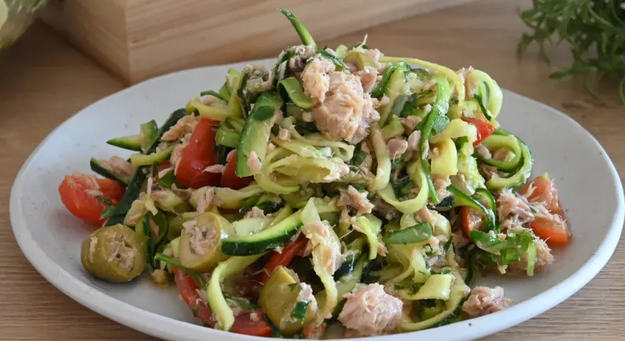 Deliziosa insalata di zucchine a spirale con tonno, pomodorini e olive verdi. Un piatto fresco e leggero.