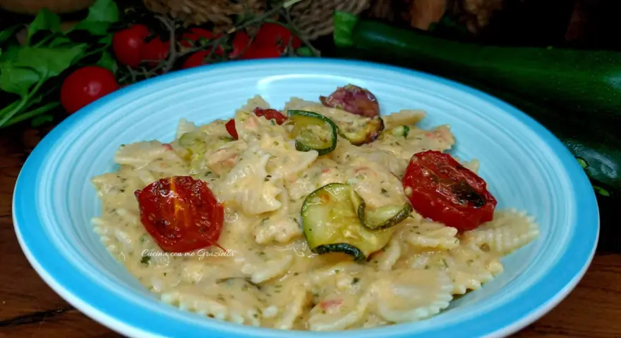 Farfalle cremose con zucchine e pomodorini confit, un piatto che celebra la pasta zucchine e philadelphia.