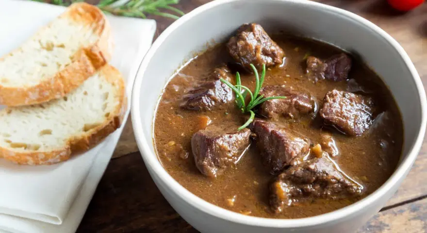 Cinghiale in umido fatto in casa da Benedetta, servito in una ciotola con pane tostato e rosmarino.