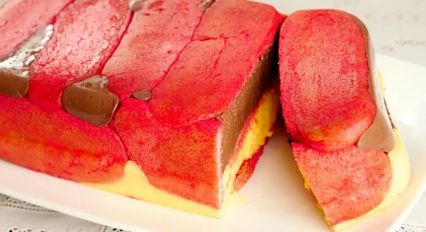 Zuppa inglese ricetta originale emiliana: strati di pan di Spagna rosa, crema al cioccolato e crema pasticcera, decorata con gocce di cioccolato.