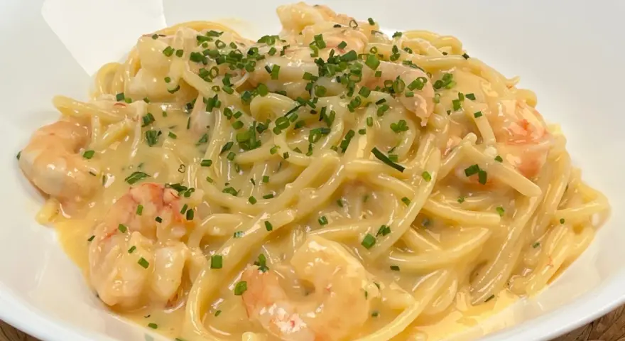 Spaghetti cremosi con gamberi e erba cipollina, una deliziosa carbonara di mare.