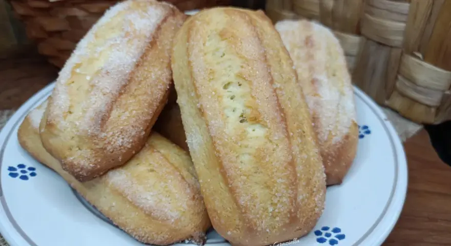 Biscotti da inzuppo dorati e zuccherati, perfetti per la colazione o la merenda. Sullo sfondo, un cestino di uova e un altro intrecciato.