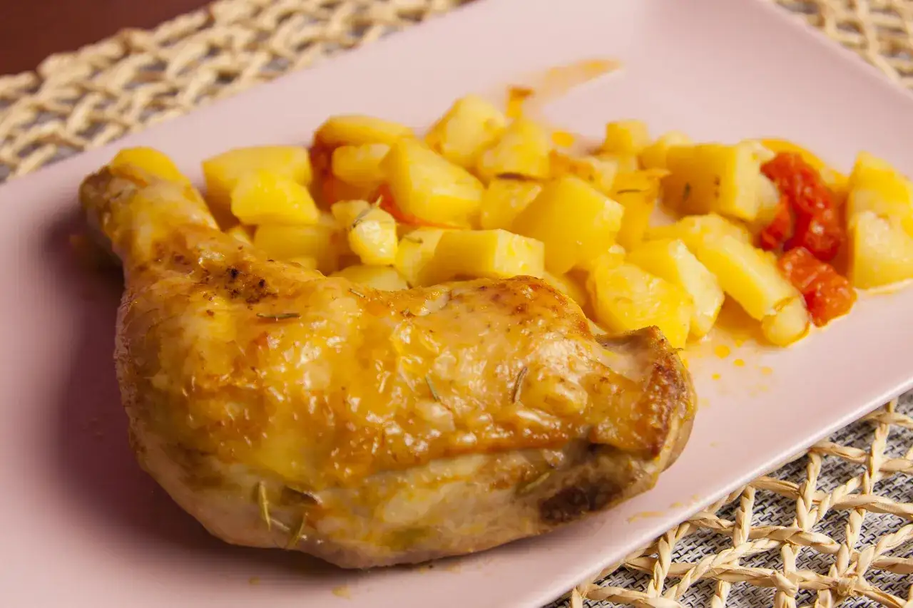 Un succulento pollo in umido con patate arrosto e pomodorini, un piatto che profuma di casa.
