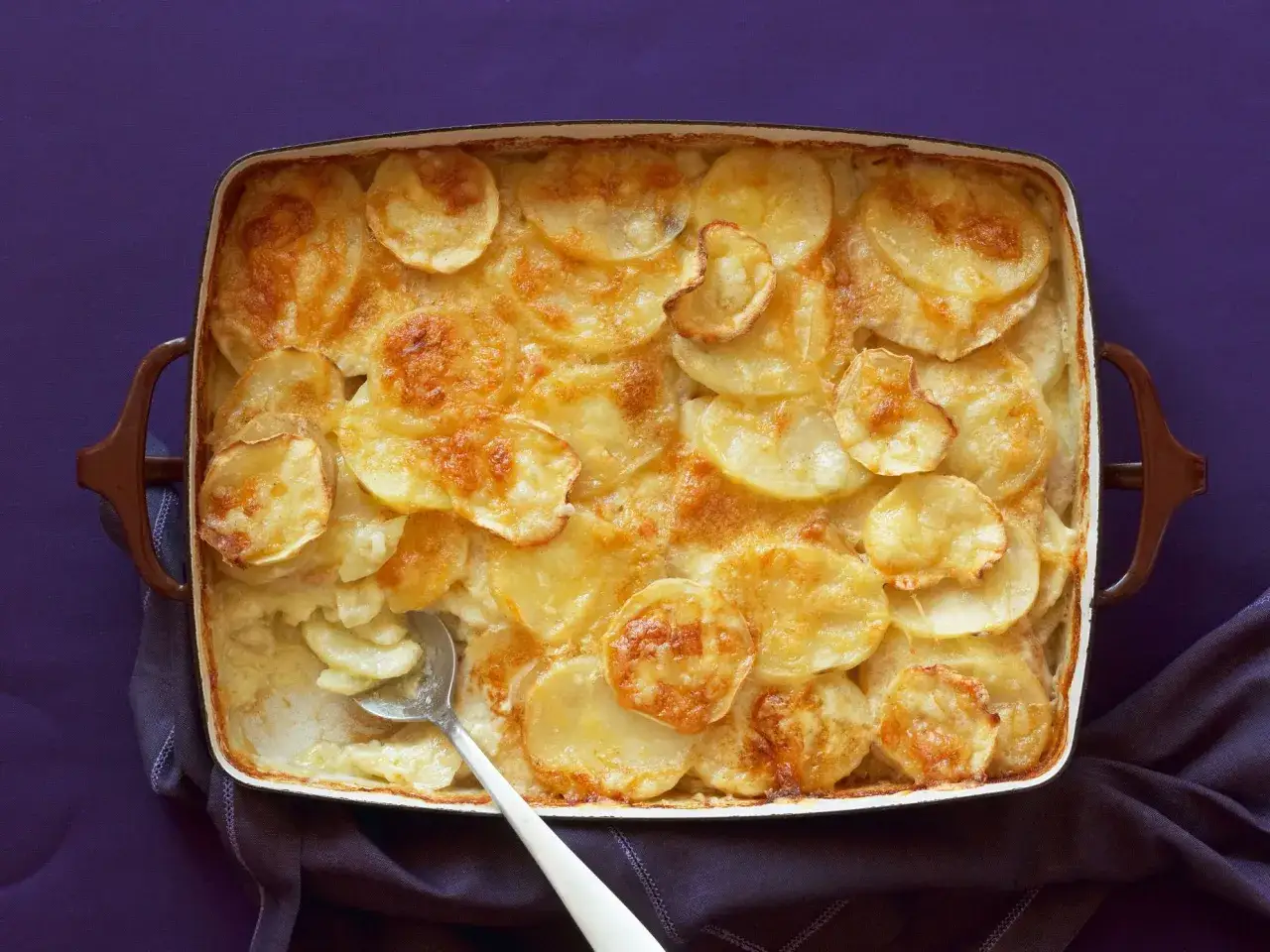 Una teglia di parmigiana di patate dorata e cremosa, pronta per essere gustata.