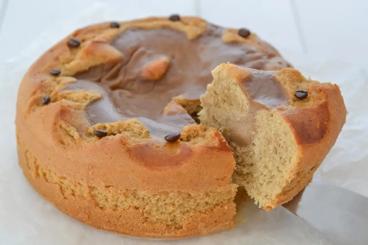 Una deliziosa torta al caff&egrave;, con una fetta tagliata e decorata con chicchi di caff&egrave;.