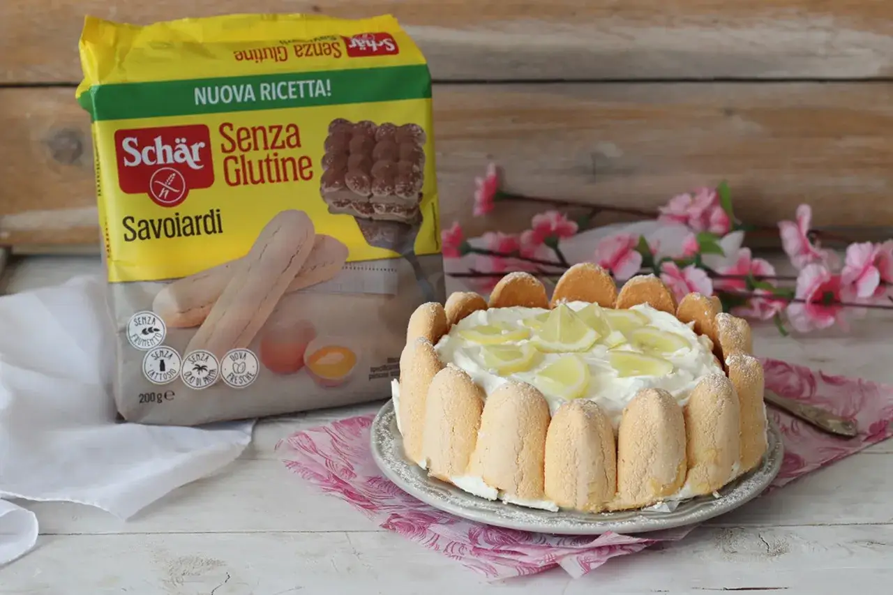 Delizioso tiramisù al limone senza glutine, preparato con savoiardi Schär e decorato con fette di limone.