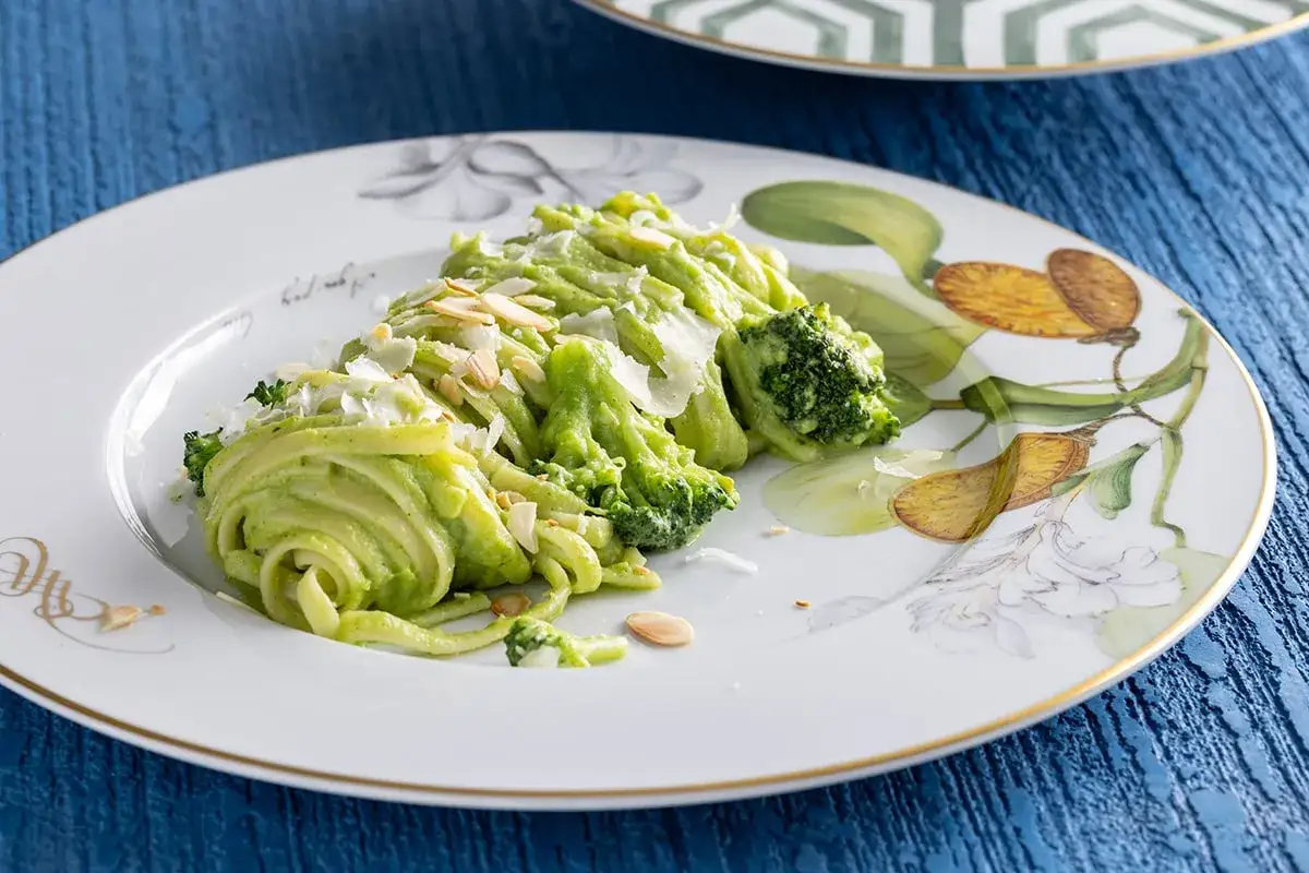 Deliziosa pasta con verdure, condita con una cremosa salsa verde, scaglie di parmigiano e mandorle tostate. Un piatto colorato e salutare.