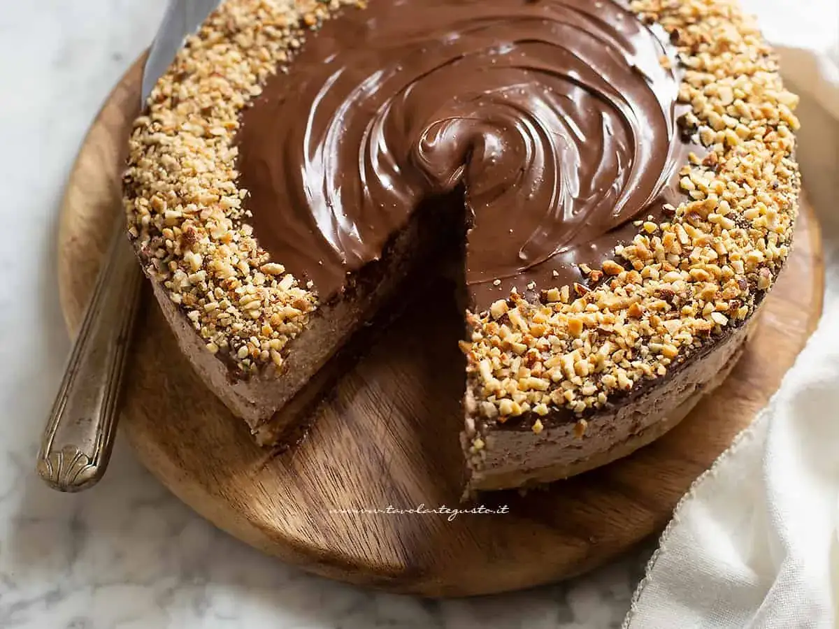 Una golosa cheesecake alla nutella, con copertura lucida e granella di nocciole croccante sui bordi.