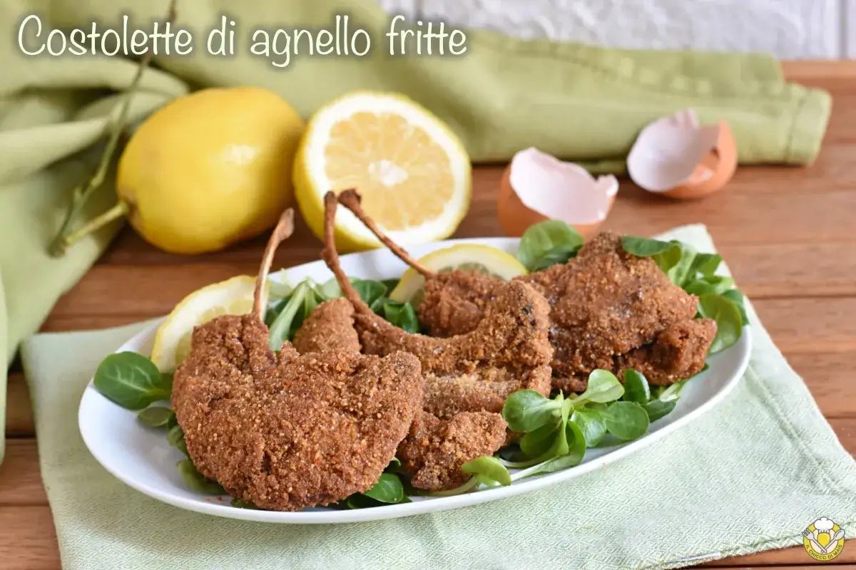 Deliziose costolette d'agnello fritte, croccanti e dorate, servite su un letto di insalata fresca con spicchi di limone.