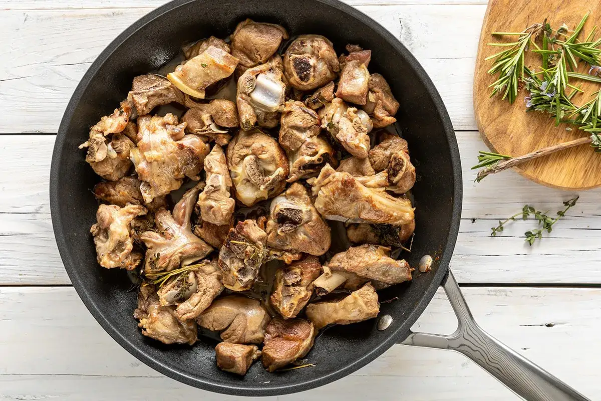 Succulento agnello in padella, cotto a puntino con erbe aromatiche. Un piatto invitante pronto per essere gustato.