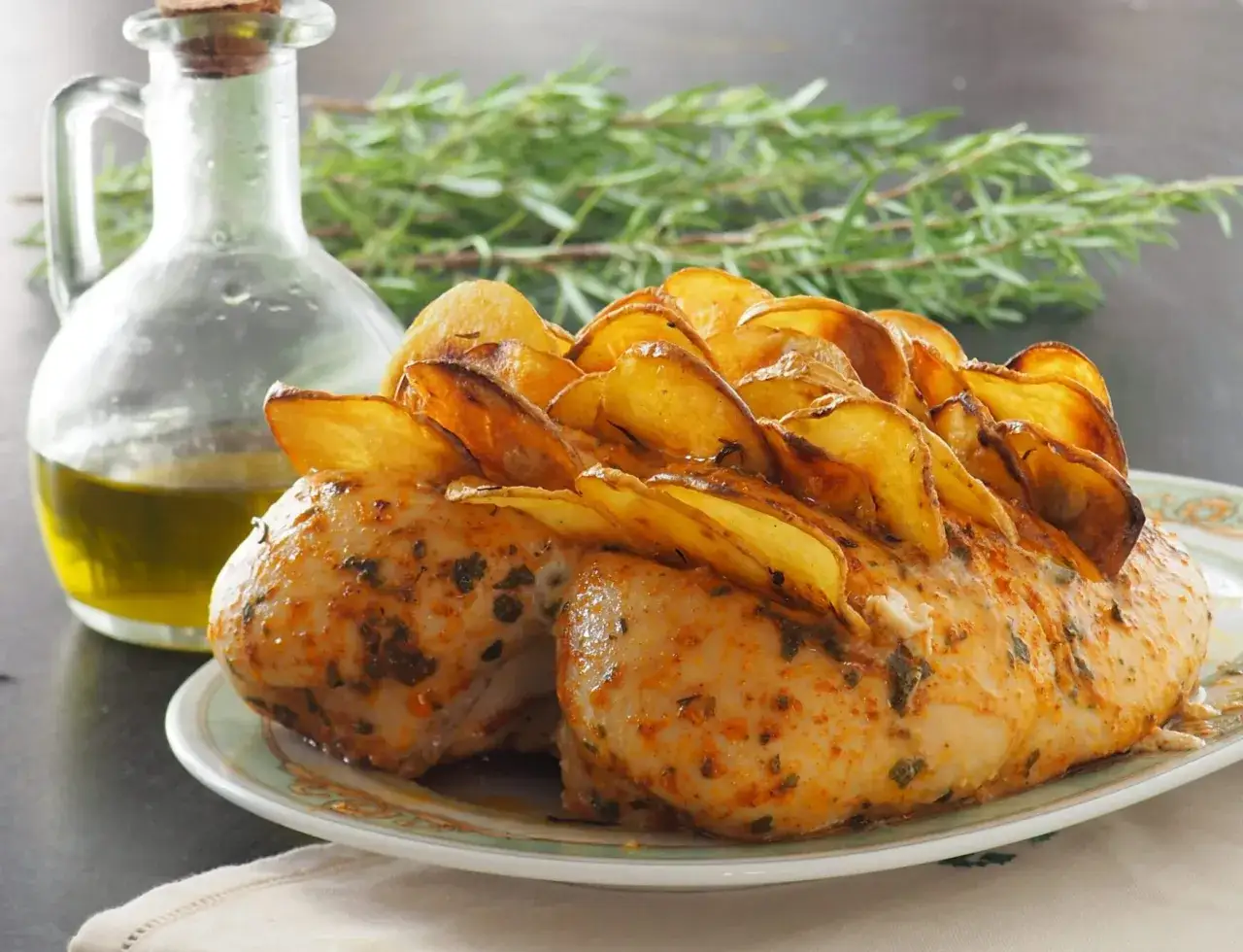 Petto di pollo al forno con patate croccanti, condito con erbe aromatiche e accompagnato da olio d'oliva.