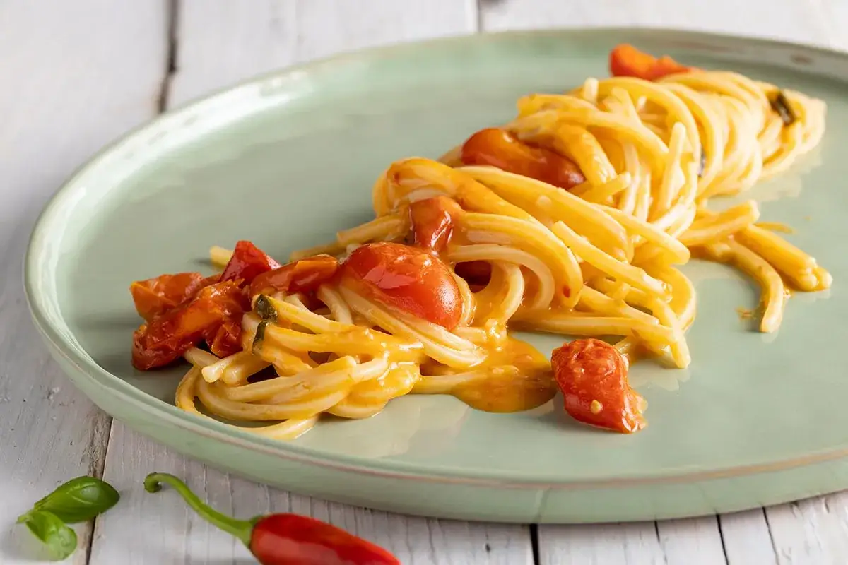 Spaghetti allo scarpariello con pomodorini e peperoncino, un piatto saporito e colorato.
