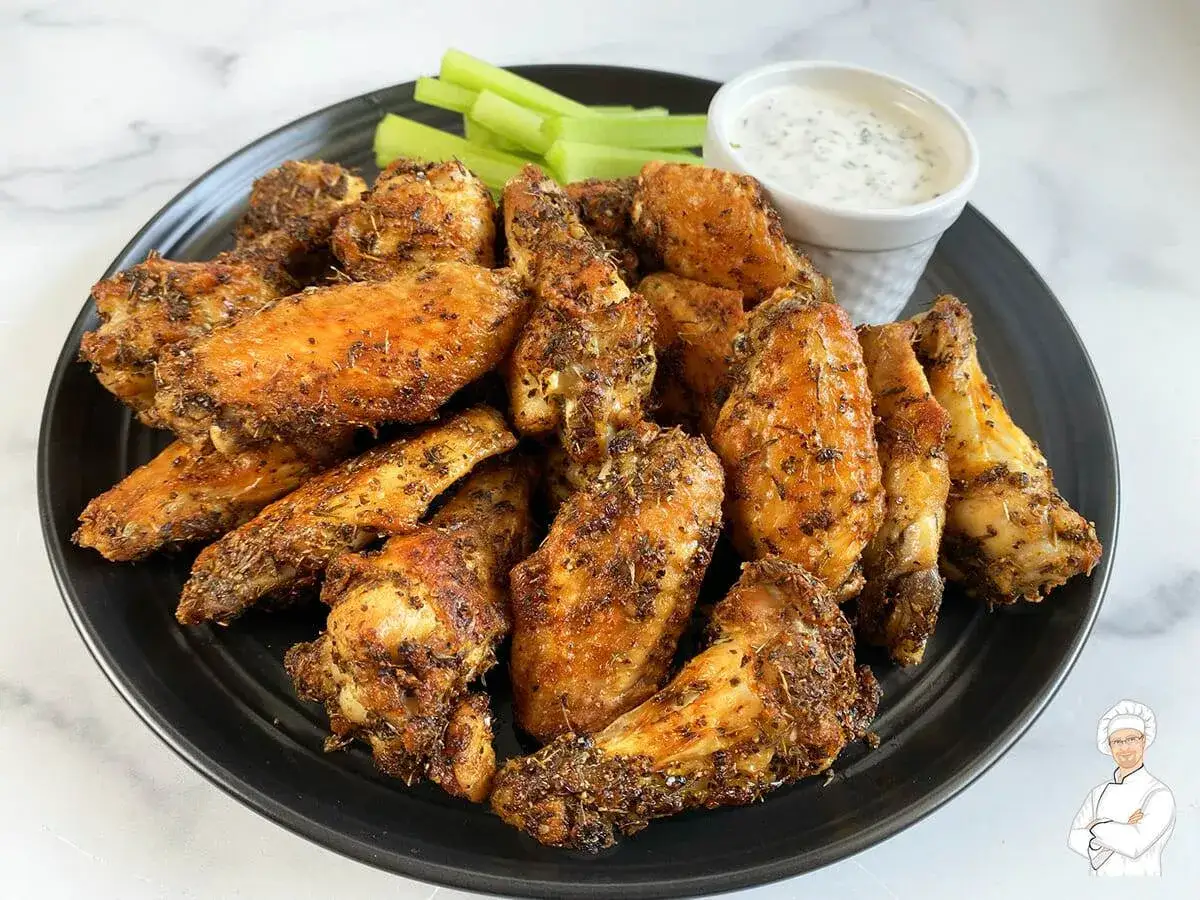 Fusi di pollo croccanti in friggitrice ad aria, serviti con salsa e sedano.