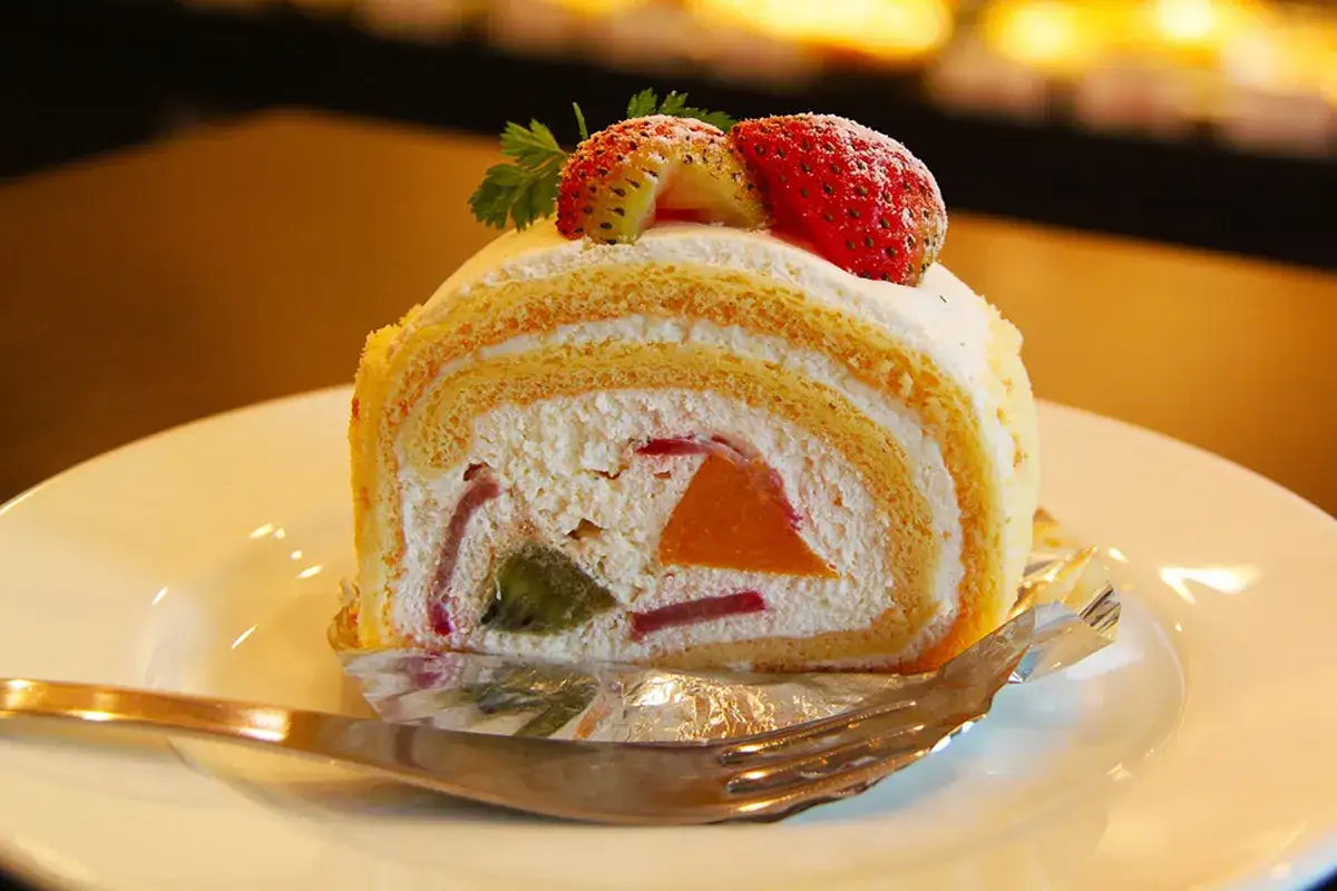 Fetta di torta al mascarpone con frutta e fragole fresche, un dolce invitante.