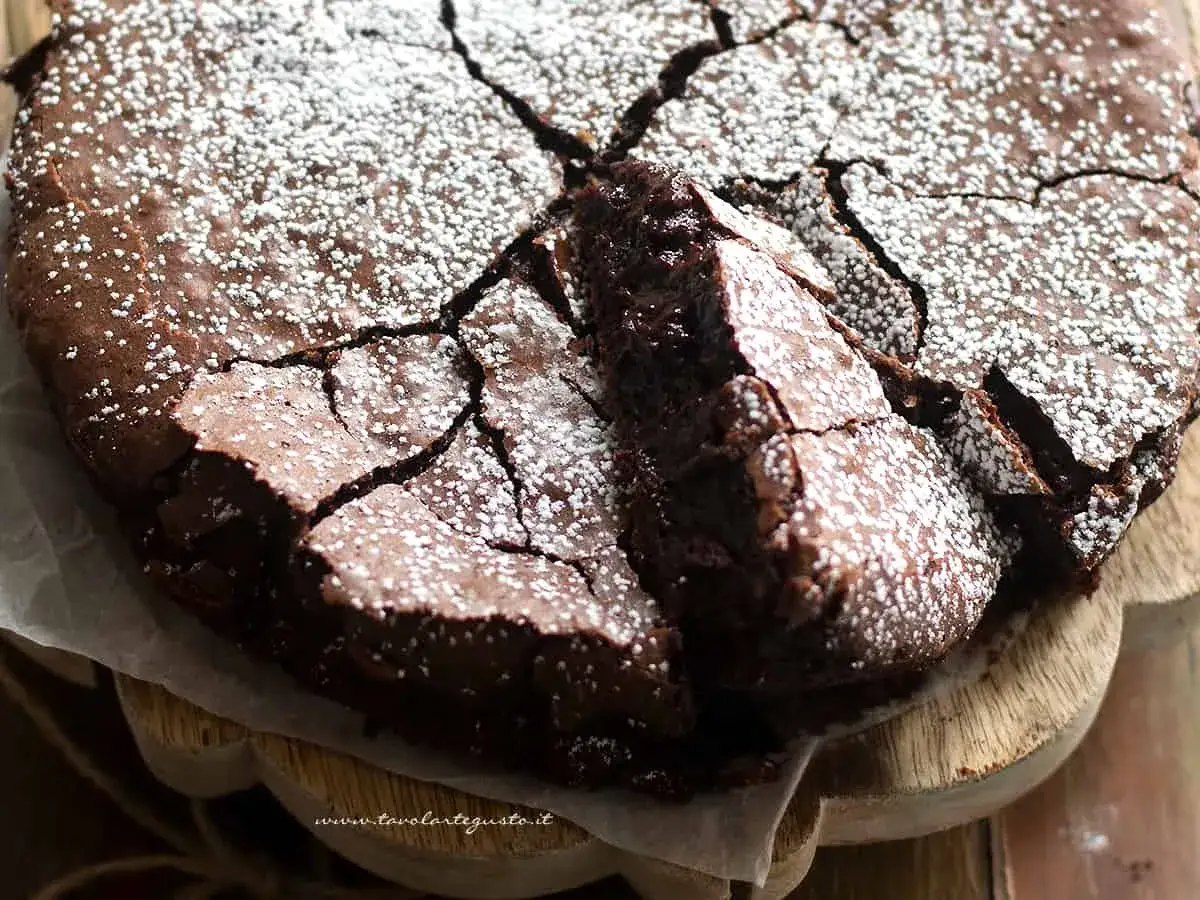 Una deliziosa torta al cioccolato, con una crosta screpolata e cosparsa di zucchero a velo, pronta per essere gustata.